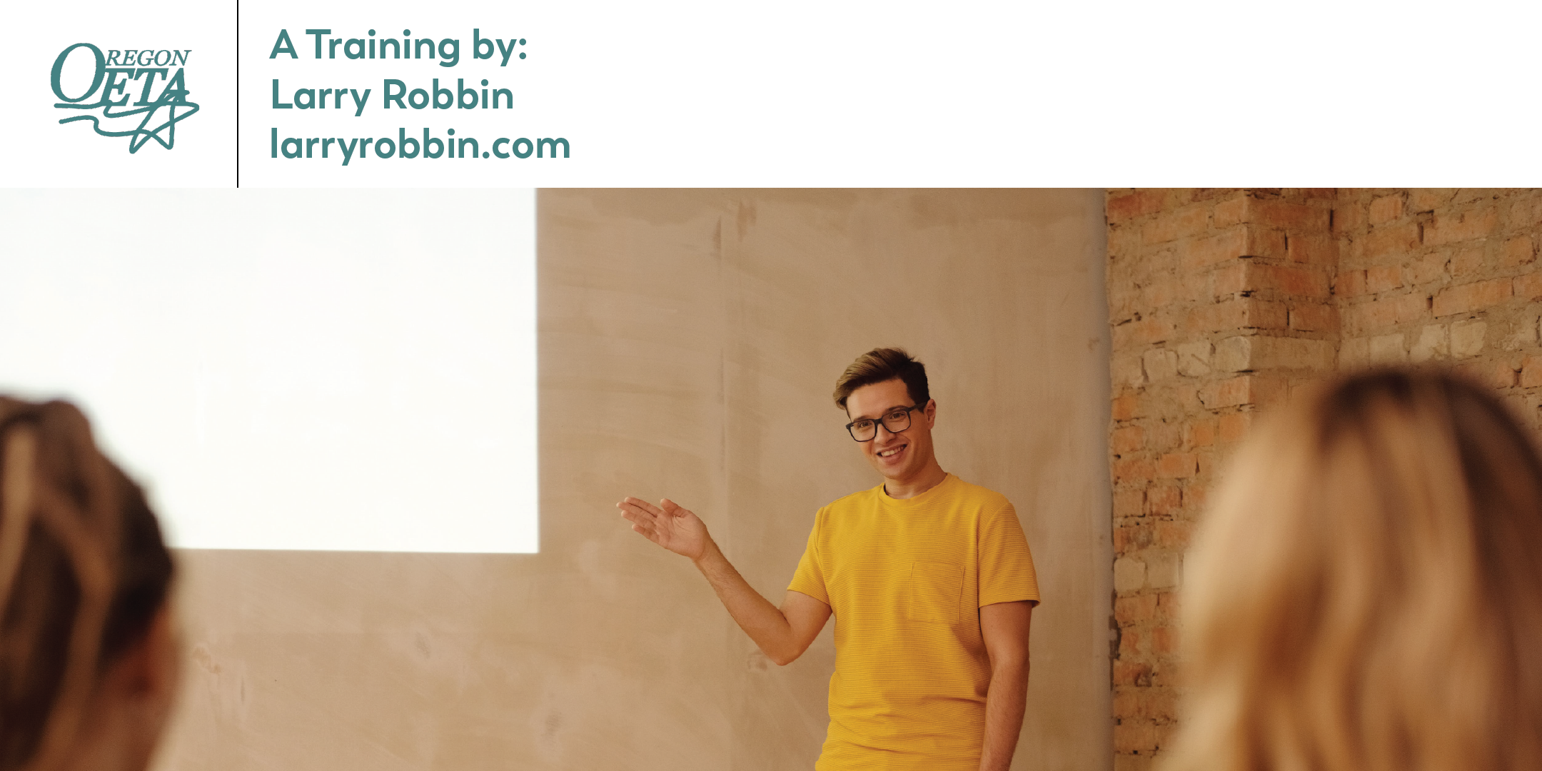 Man in a yellow shirt pointing to a lit up board